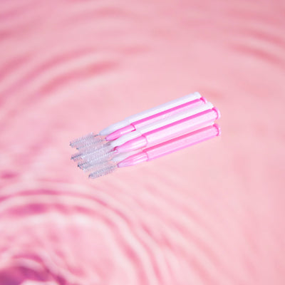 Brow Lamination Comb Brush pack in front of pink background.