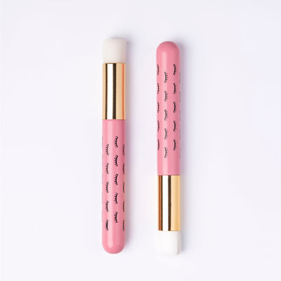 Two pink wooden cleansing brushes over light background