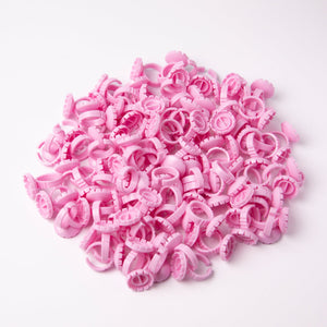 Pink Glue Rings (100 pcs) over a white background. 