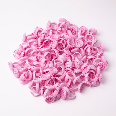 Pink Glue Rings (100 pcs) over a white background. 