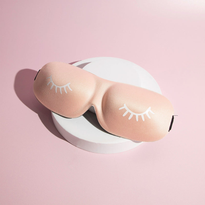 Pink coloured 3D Contoured Sleep Masks in front of a pink background..