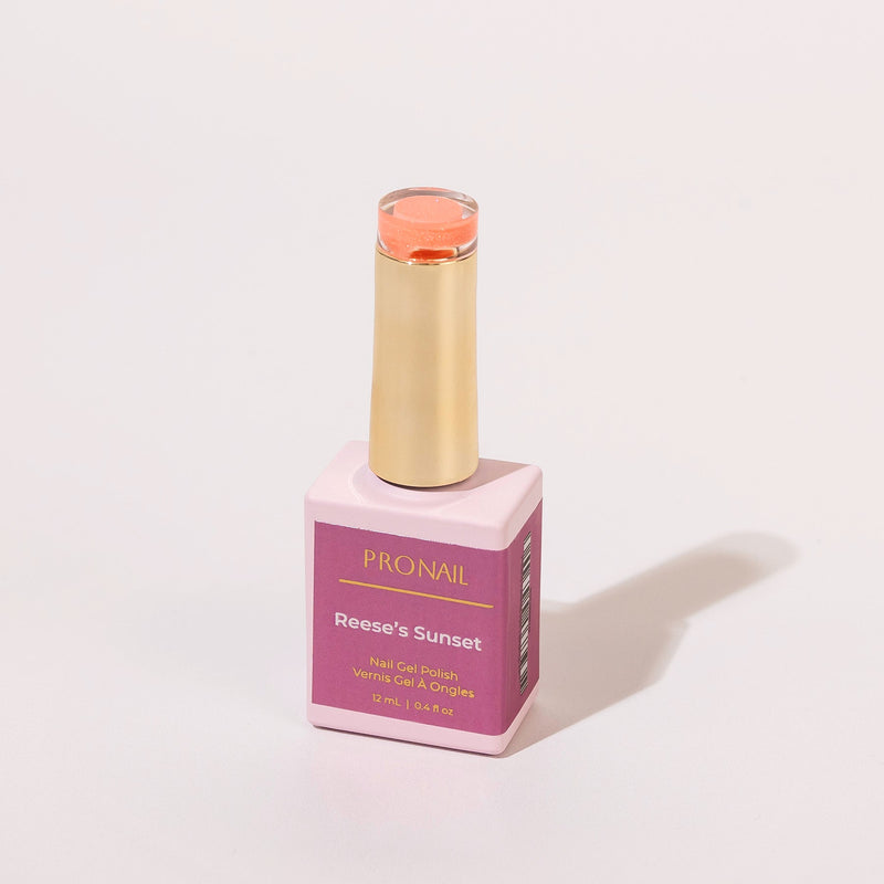 A square nail polish bottle with a gold cap casting a shadow on a white background.