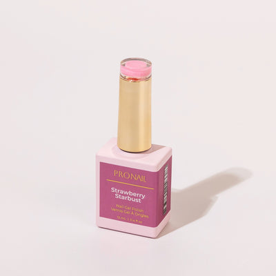 A Strawberry Starbust_ nail polish bottle with a gold cap casting a shadow on a white background.