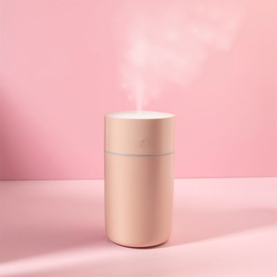 Image of the humidifier turned on with a pink background. 