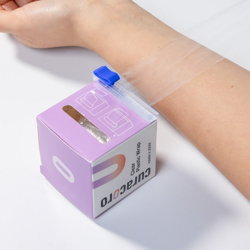 Curacoro clear plastic wrap applied to an arm, with packaging and cutter shown, 42mm x 200m.