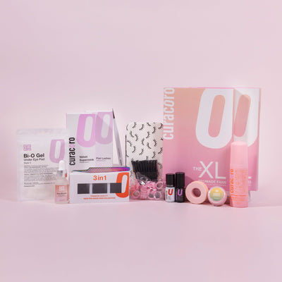 Curacoro Eyelash Extension Training Kit displayed on a soft pink background.