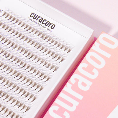 Curacoro Lashfolio Dark Brown individual lash extensions in a white tray with a pink gradient box.