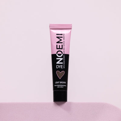 Noemi Hybrid Brow & Lash Dye - Light Brown Bottle Over Pink Background