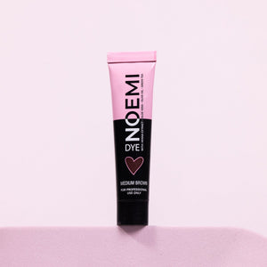 Noemi Hybrid Brow & Lash Dye - Medium Brown Bottle Over Pink Background