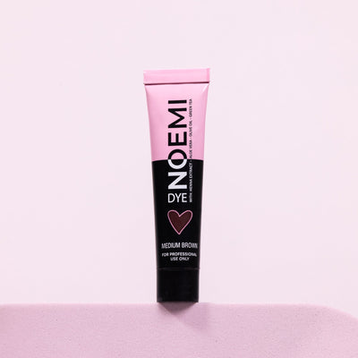 Noemi Hybrid Brow & Lash Dye - Medium Brown Bottle Over Pink Background