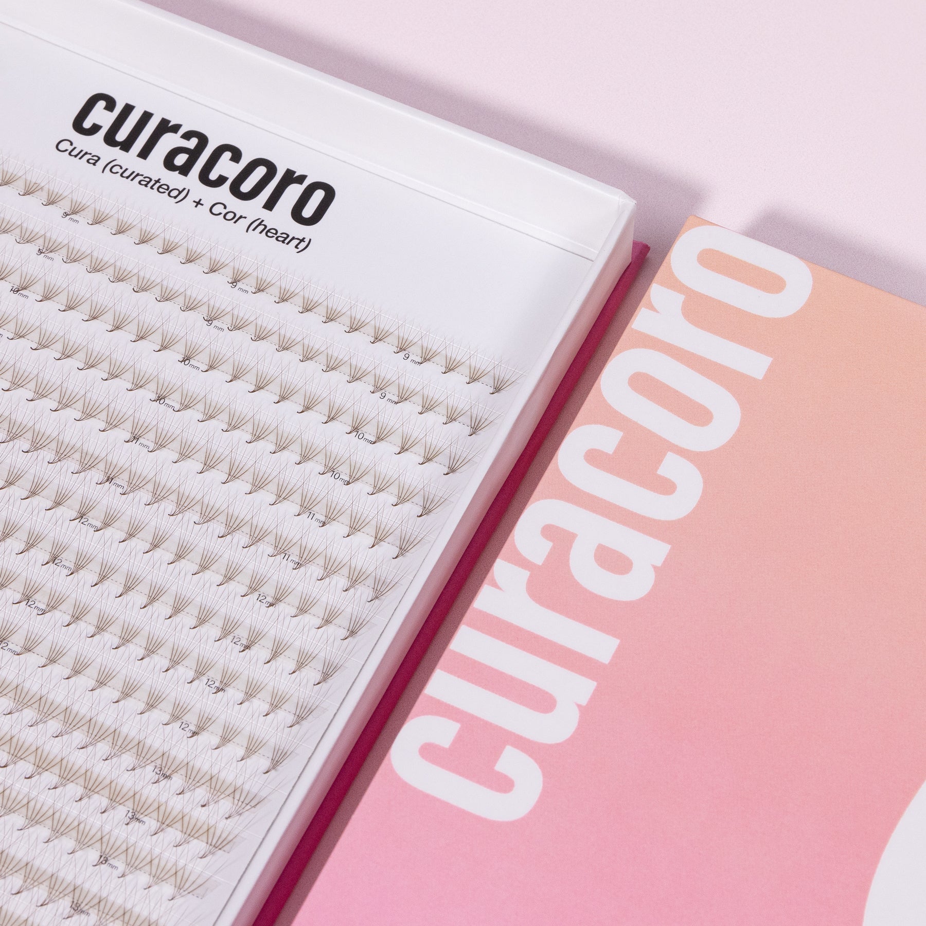 Close-up of a lash fan tray and its pink gradient packaging, showing the Curacoro branding on a light pink surface.