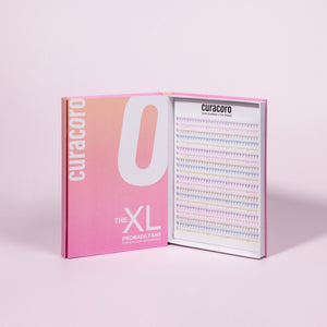 Curacoro XL Promade Fans tray with rainbow-colored lash extensions, displayed in an open box with pink gradient packaging.