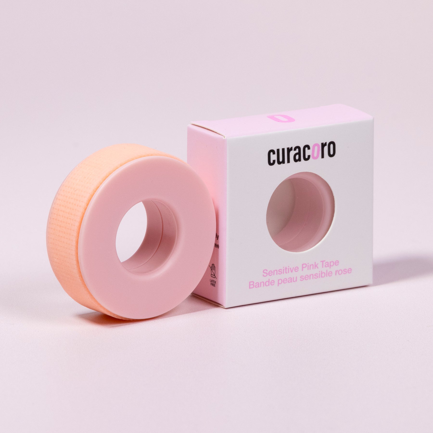 Curacoro sensitive pink tape for eyelash extensions with soft silicone core, shown with packaging on soft pink background