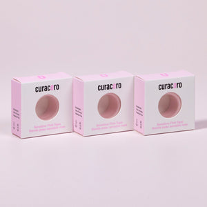 Curacoro sensitive pink tape for eyelash extensions, three boxes displayed in a row on soft pink background