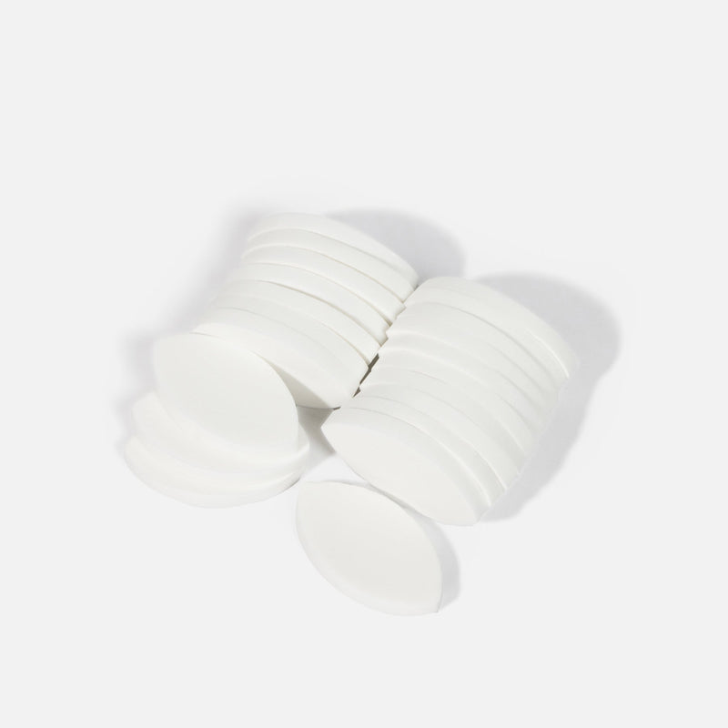 Stacked White Lash Practice Sponge pieces arranged in neat piles on a white background.