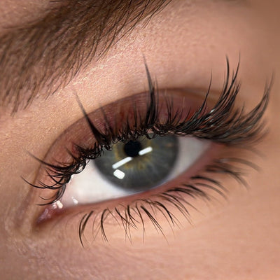 Close-up of a model's eye with anime-inspired lash extensions, emphasizing a natural yet dramatic curl and volume.