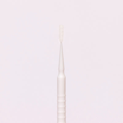 White disposable micro applicator with a fine brush tip, ideal for precise application of beauty products.