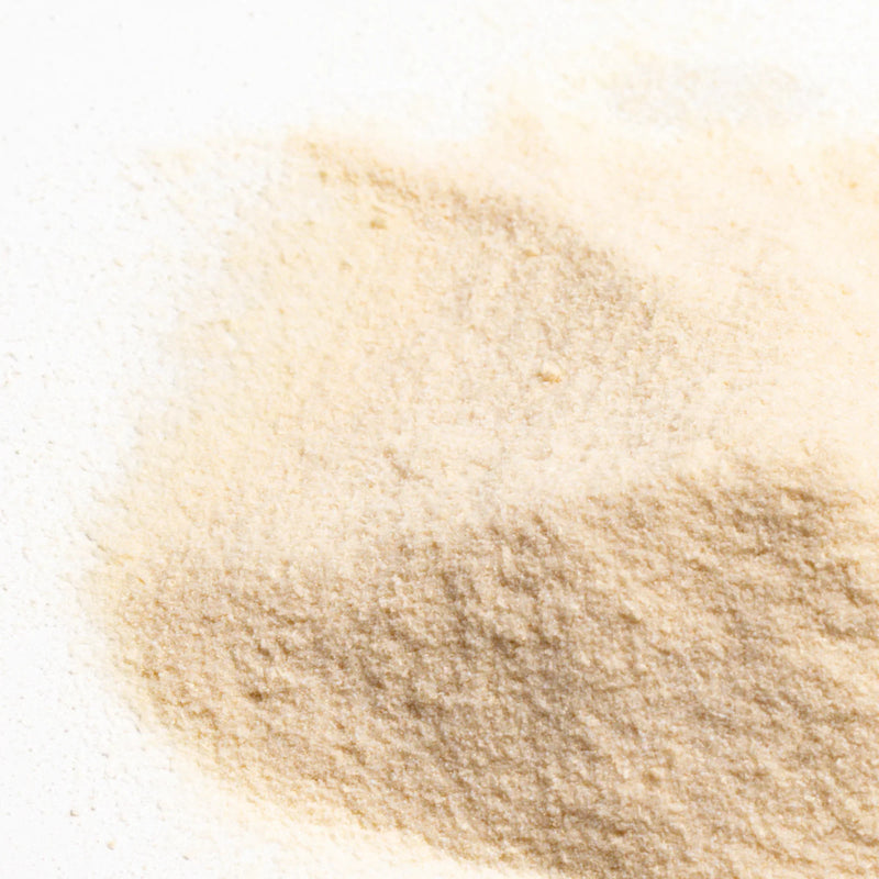 Close-up of fine beige powder texture spread across a white surface.