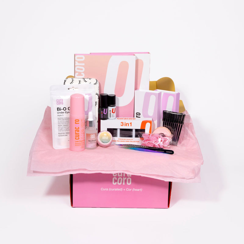 Curacoro beauty gift box with lash and skincare products on pink tissue paper, set against a white background.