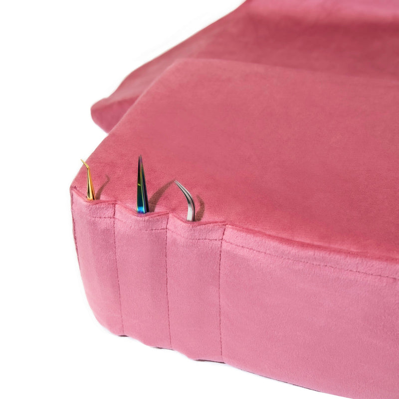 Pockets of the pink Memory Foam Pillow holding lash extension tweezers.