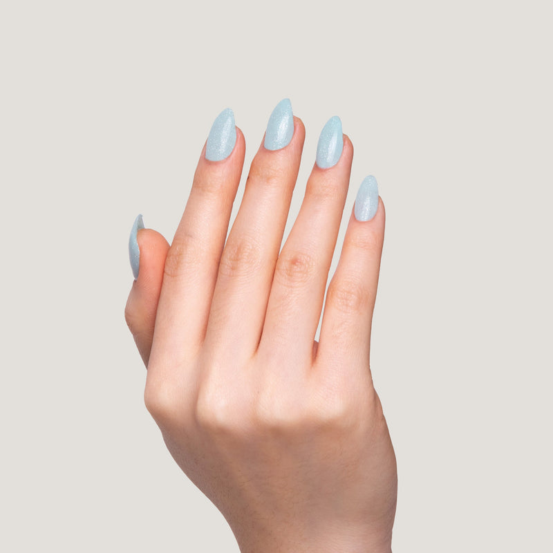 A hand with long, glossy Bubblegum nails held against a light beige background.