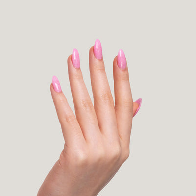 A hand with long, glossy Cotton Candy nails held against a light beige background.