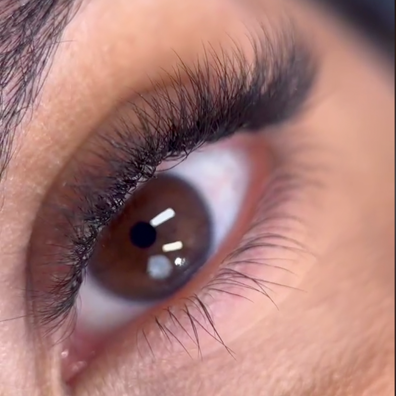 A close-up of an eye with well-defined, natural-looking eyelash extensions, highlighting the detail and quality of the lash application.