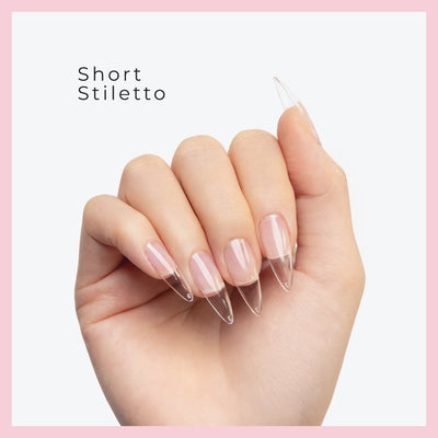 Curacoro Short Sitletto Soft Gel Nail Tips on a hand, featuring natural nails with clear extensions, set against a white background with a pink border.