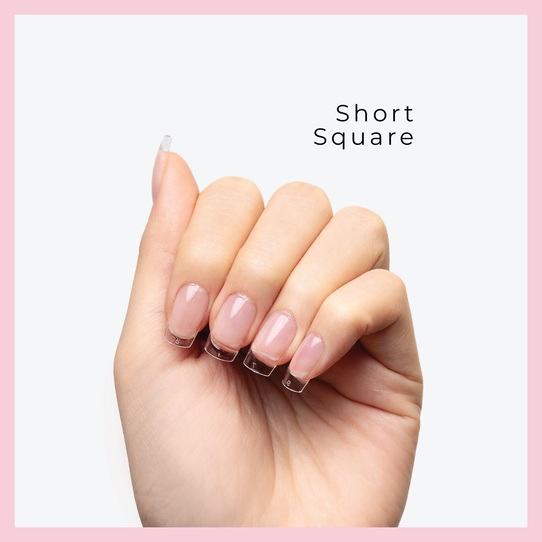 Short nail tips displayed on fingers with a clean, pink-bordered background.