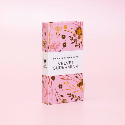 Velvet Supermink packaging with a floral design and 'Premium Quality' label, displayed on a soft pink background.