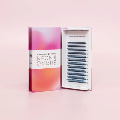 Curacoro Neon & Ombré lash tray displayed in an open box with premium gradient packaging in pink and orange tones, showcasing lash extensions of varying lengths.