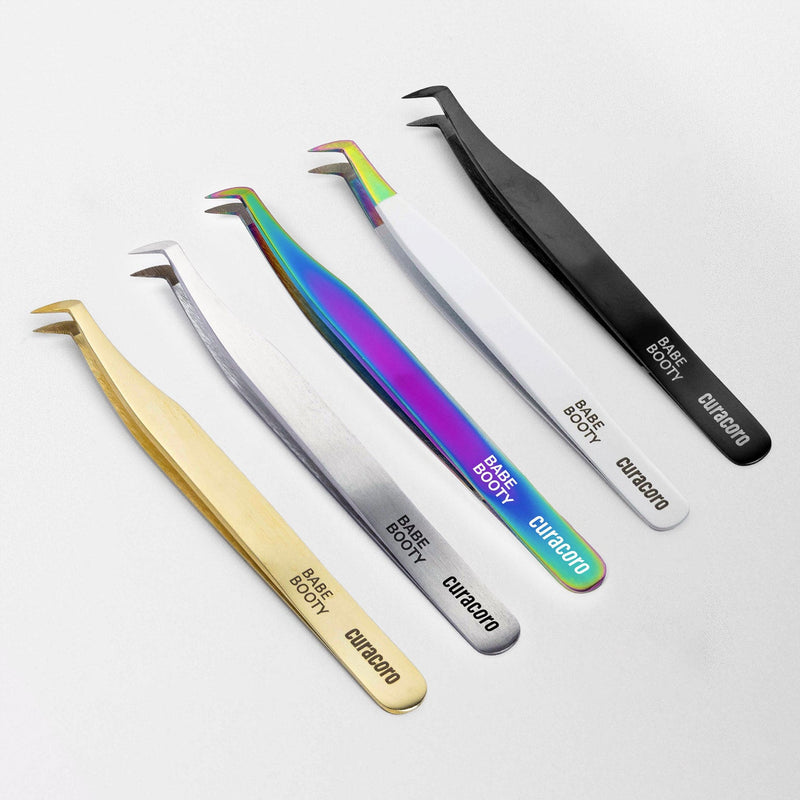 Babe Booty Tweezer Gold, Silver, Galaxy, Daisy White, Onyx over a white background. 