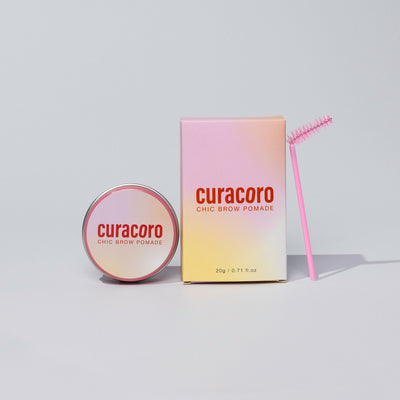 Curacoro Chic Brow Pomade with in front of a light background.