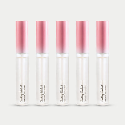 Five bottles of Curacoro Coating Sealant for lash extensions, featuring a sleek design with a gradient pink cap.