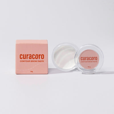 Image of our Contour Brow Paste and case box standing in front of a pink background.